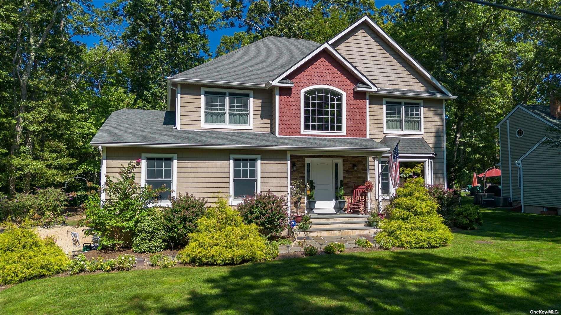 a front view of a house with a yard and trees