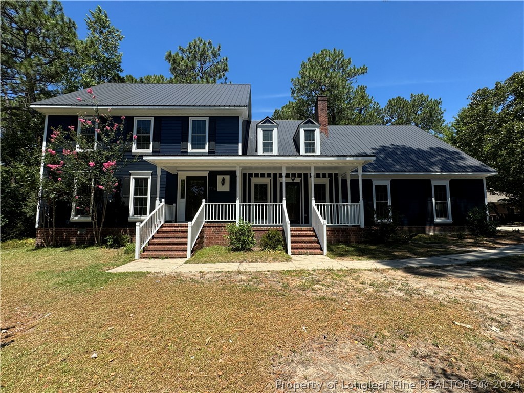 a view of a house with a yard and sitting area