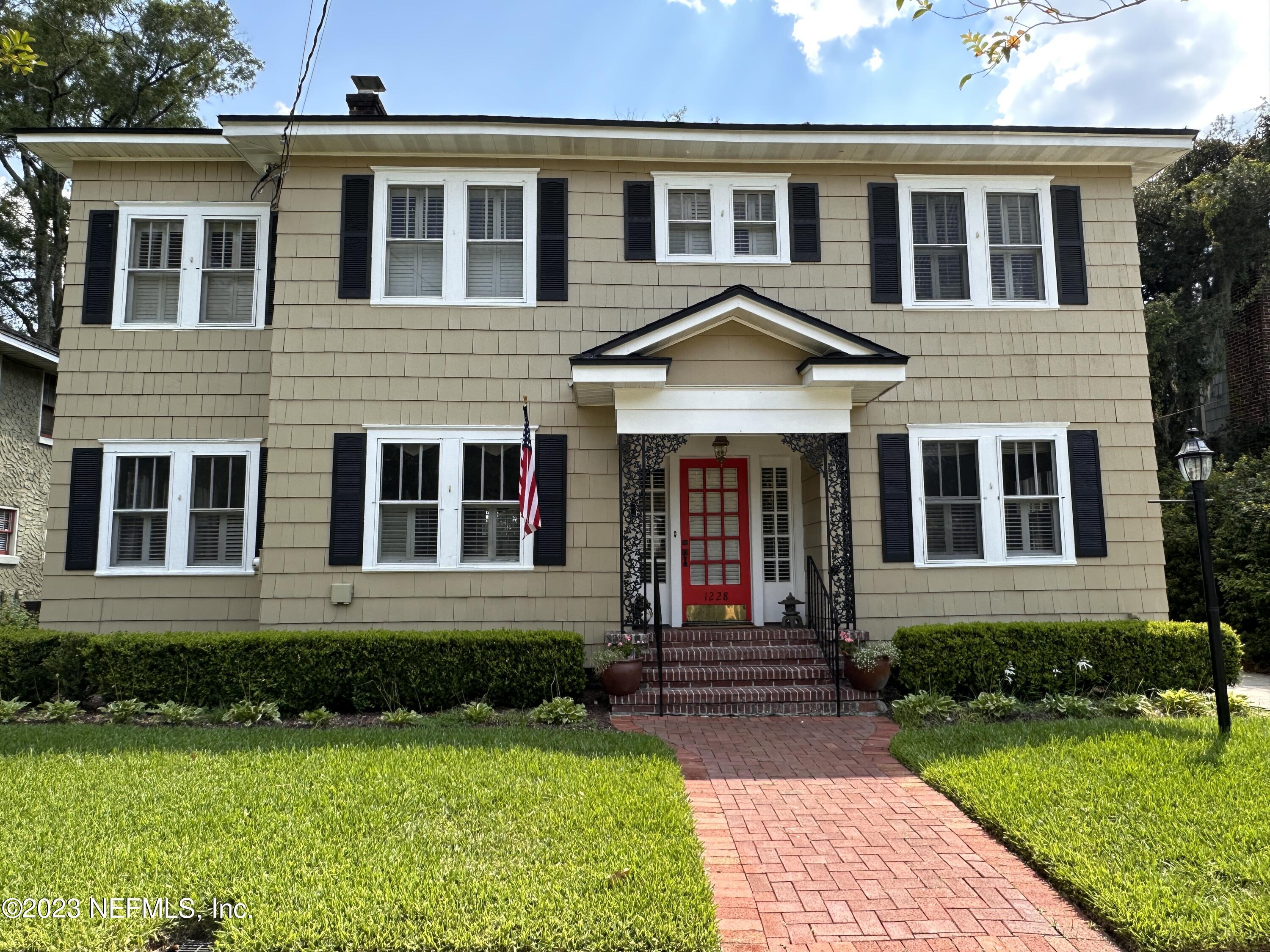 front view of a brick house with a yard