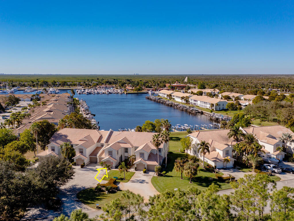 an aerial view of ocean and residential houses with outdoor space