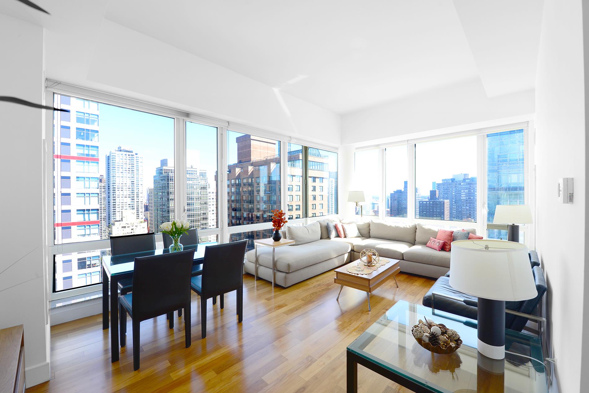 a living room with furniture and floor to ceiling windows