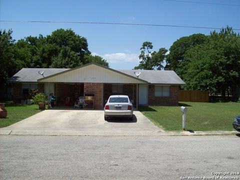 a front view of a house with a yard and trees