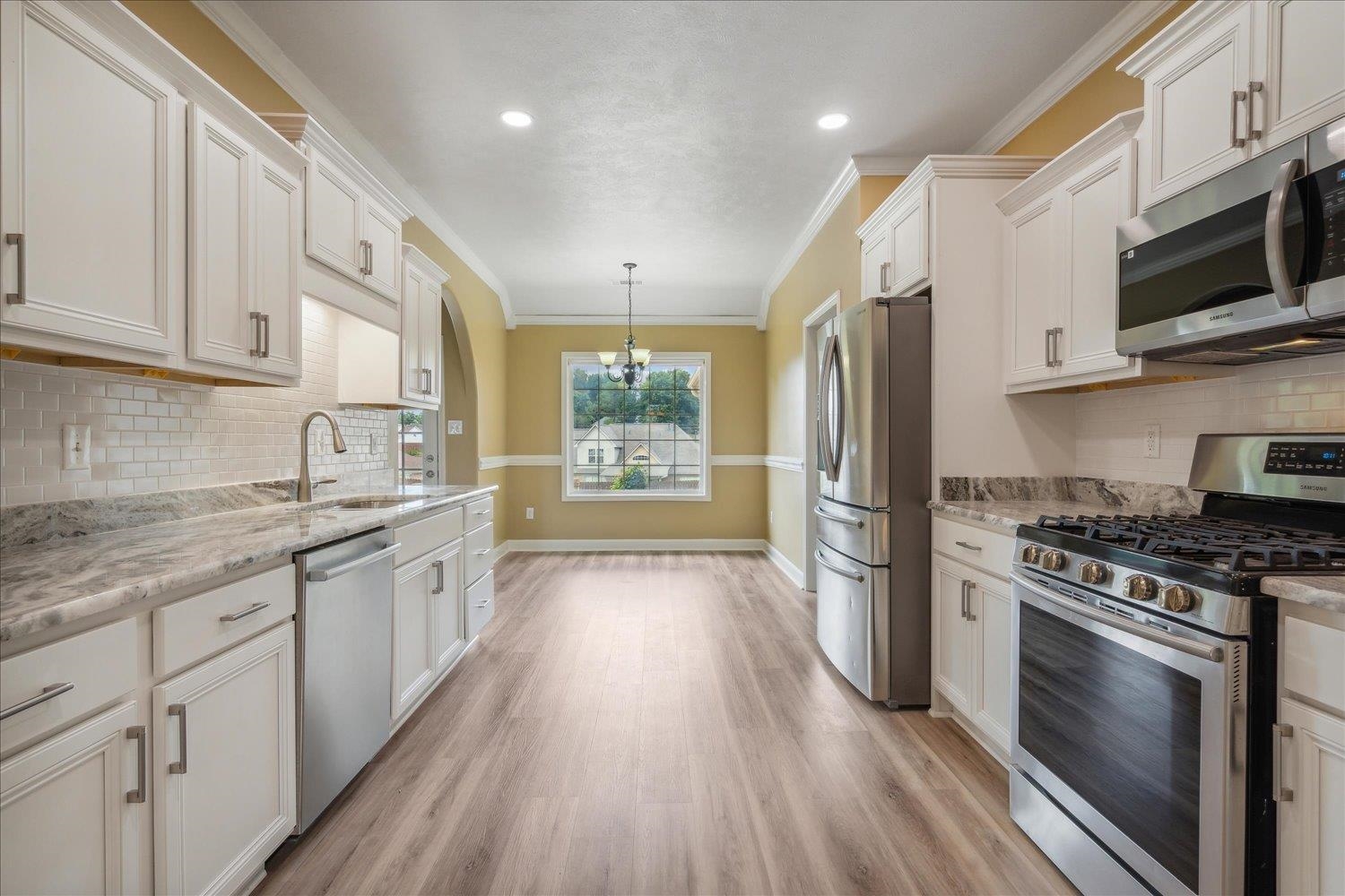 a kitchen with stainless steel appliances a stove sink and refrigerator