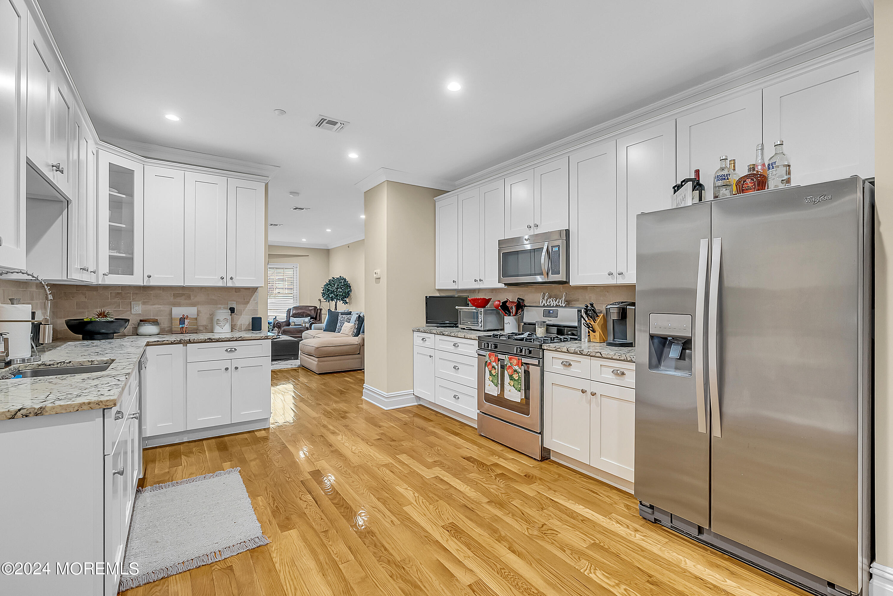 a kitchen with white cabinets and stainless steel appliances