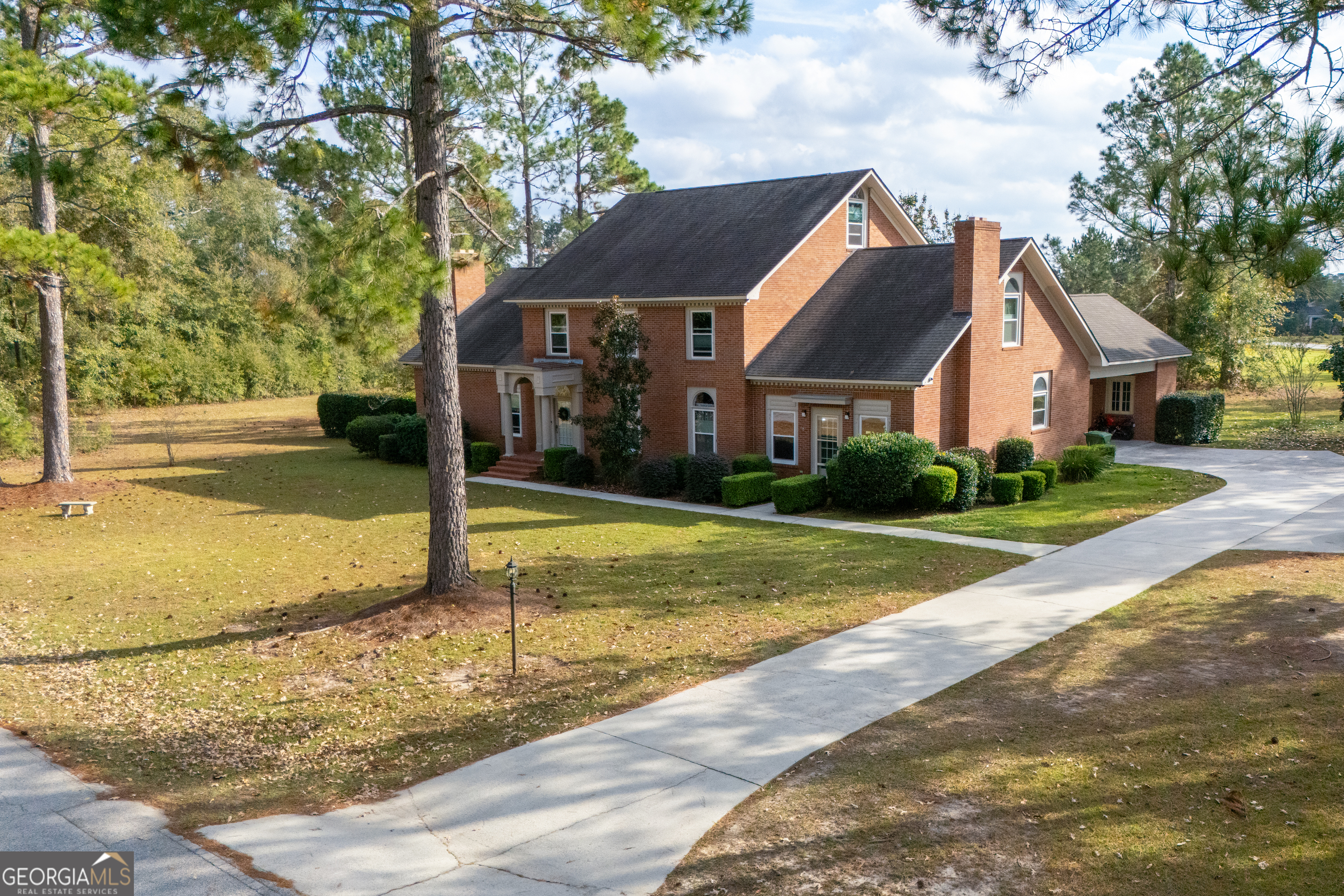 a view of a house with a yard and large tree