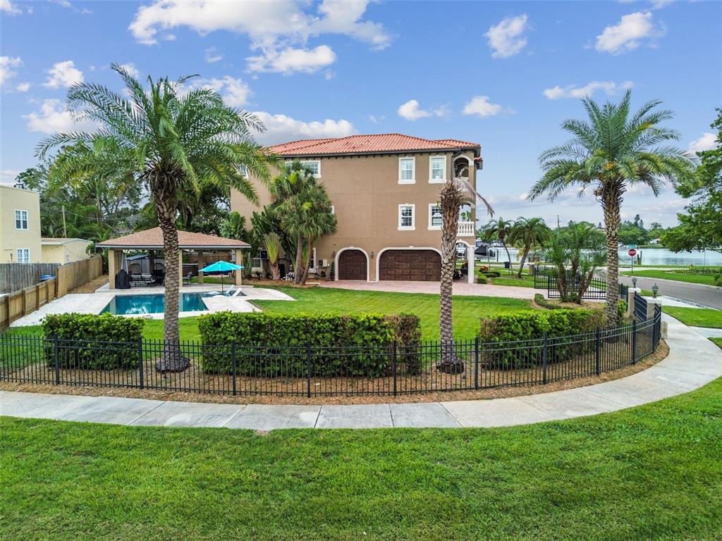 a view of a house with a big yard and potted plants