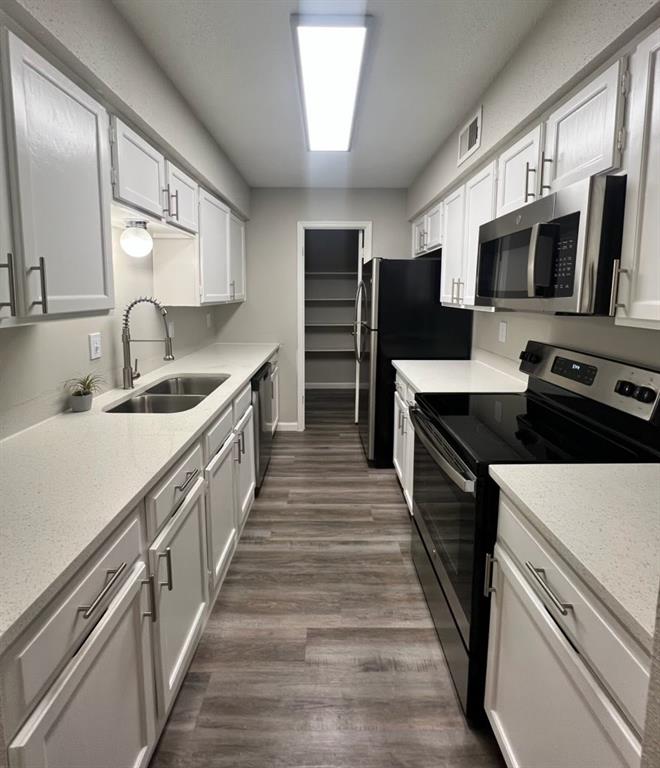 a kitchen with stainless steel appliances a sink stove and microwave