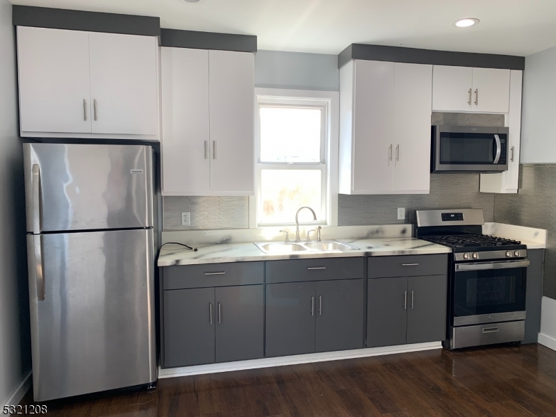 a kitchen with appliances a sink and a window