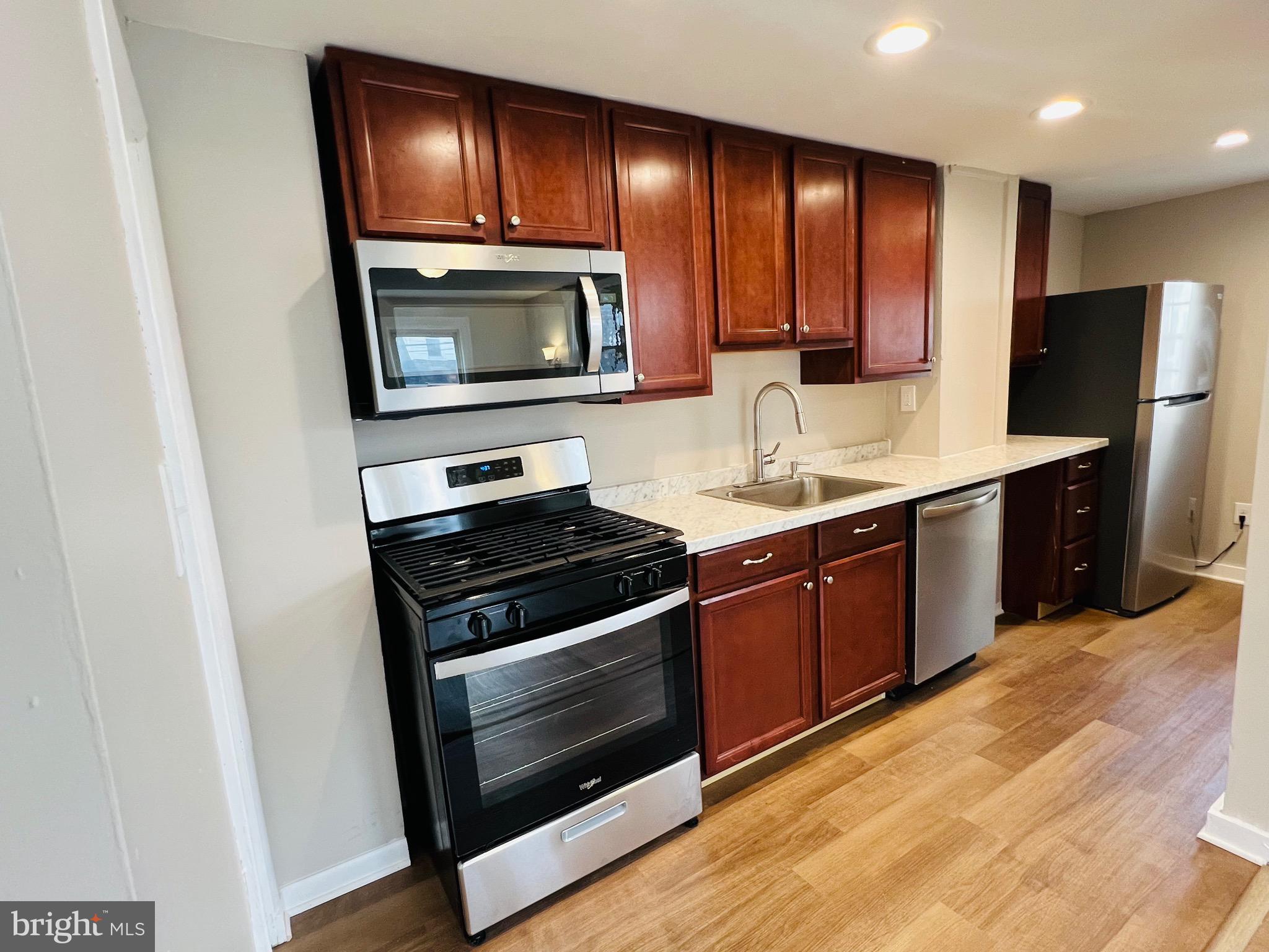 a kitchen with sink stove and microwave