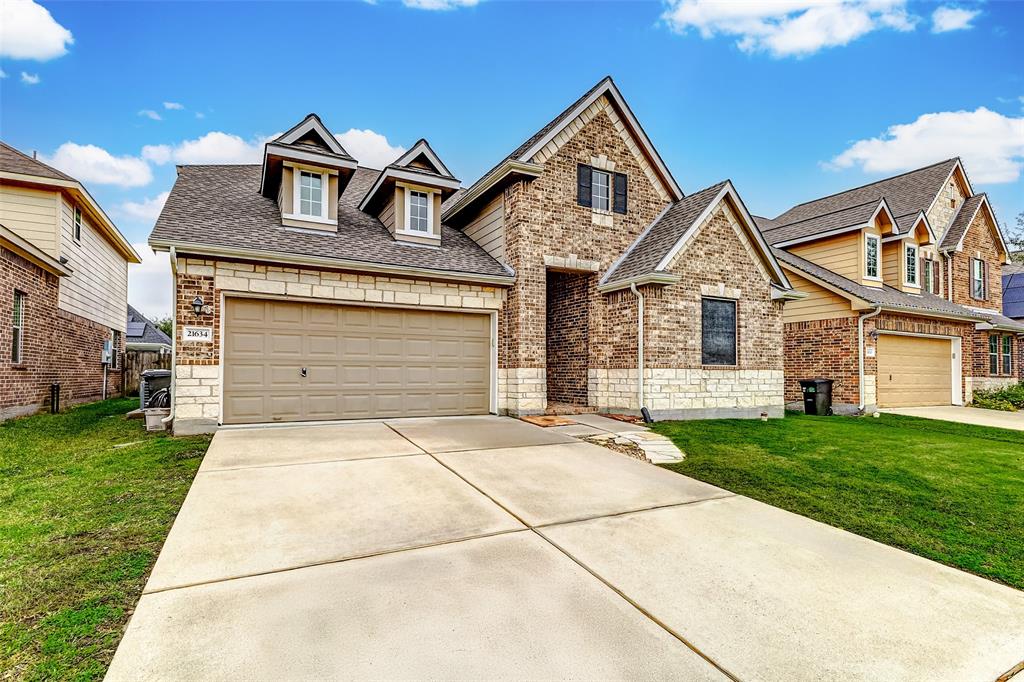 This home has immaculate curb appeal. The brick and stone exterior creates an inviting welcome. The landscaping is well-maintained, and the lawn is lush and green.