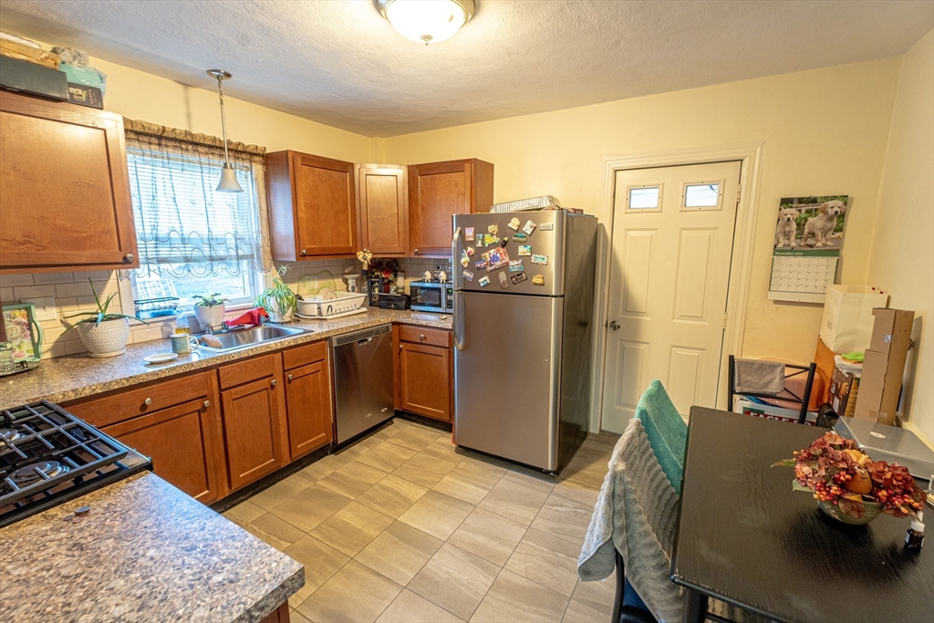 a kitchen with a refrigerator and wooden cabinets