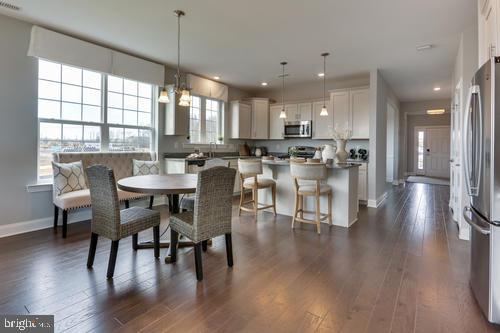 a view of a dining room and livingroom with lots of furniture and wooden floor