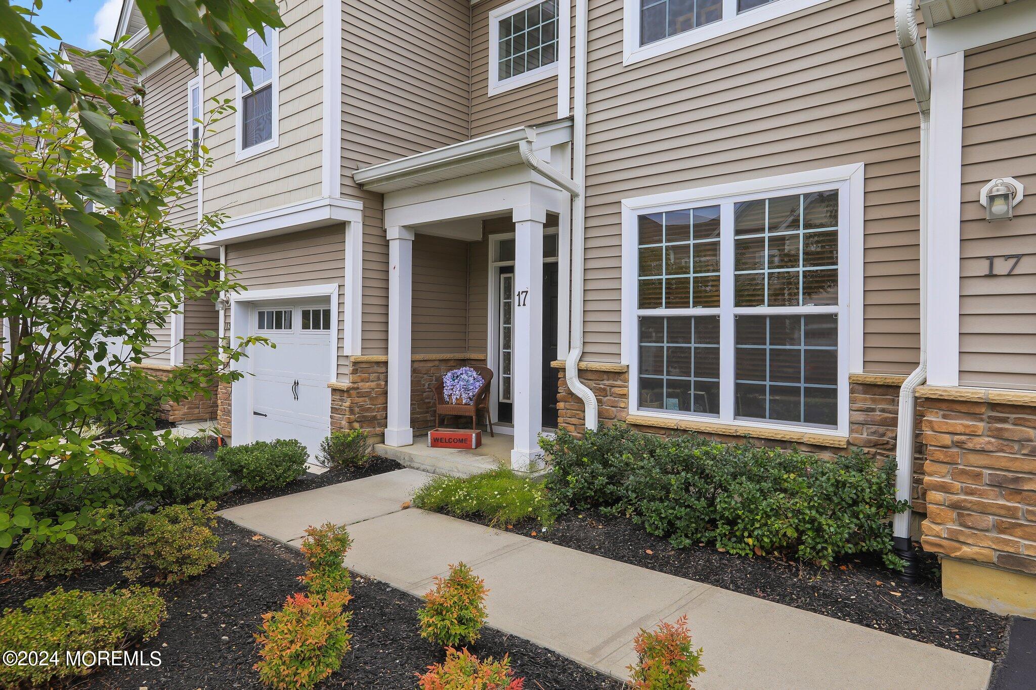 a front view of a house with a yard and a garden