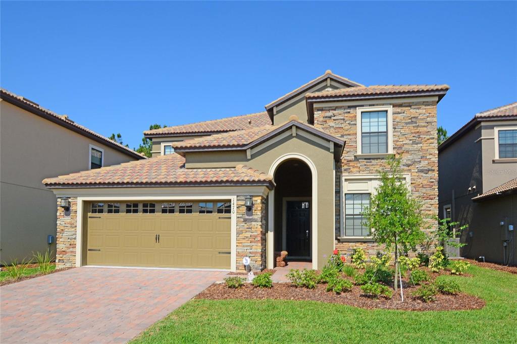 a front view of a house with a yard and garage