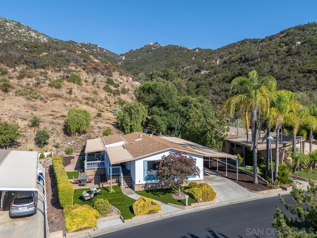 an aerial view of house with yard swimming pool and mountain view in back