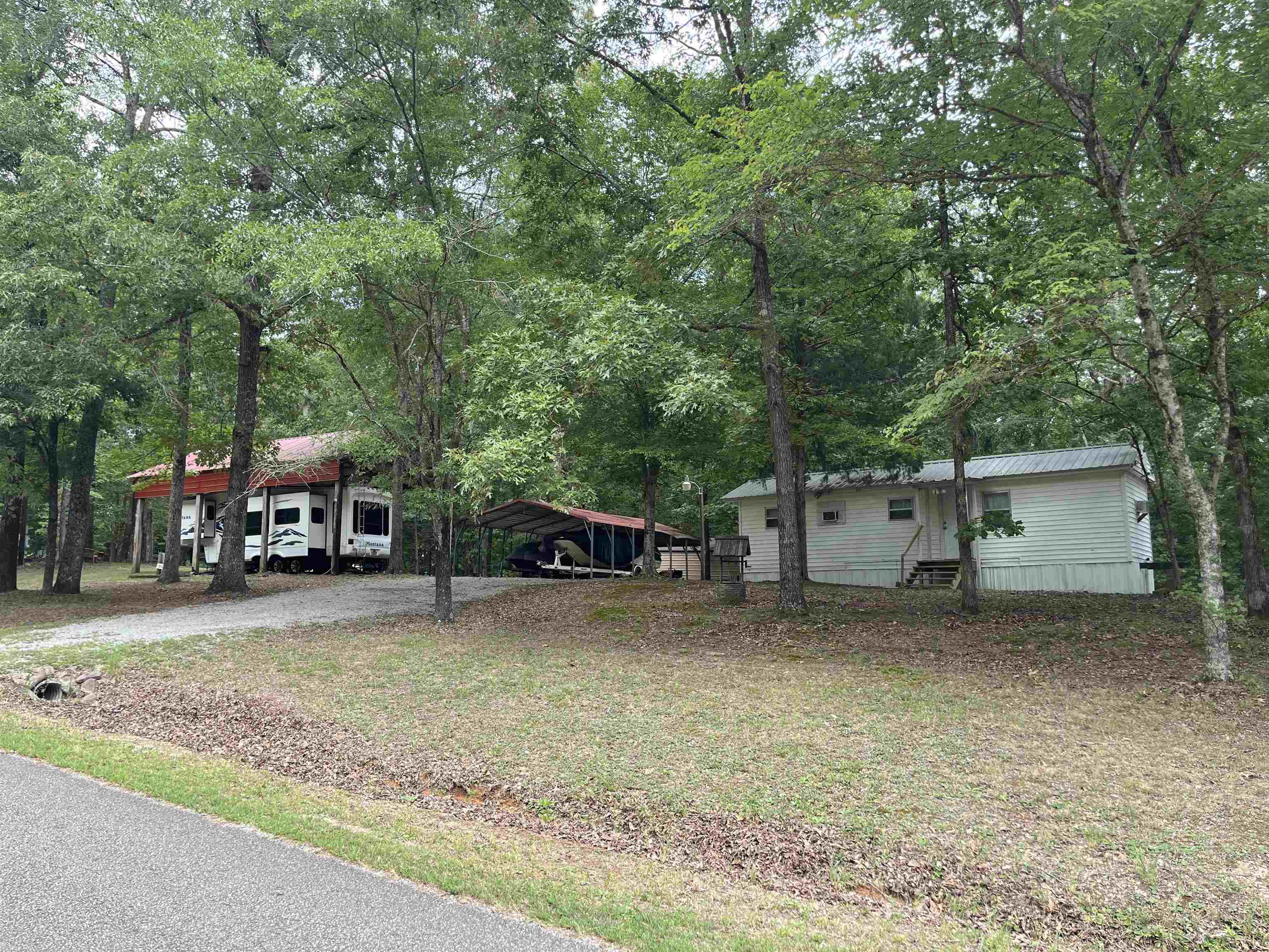 a view of a house with a yard and large trees