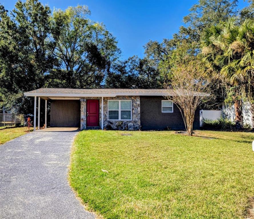 a front view of a house with yard garage and tree