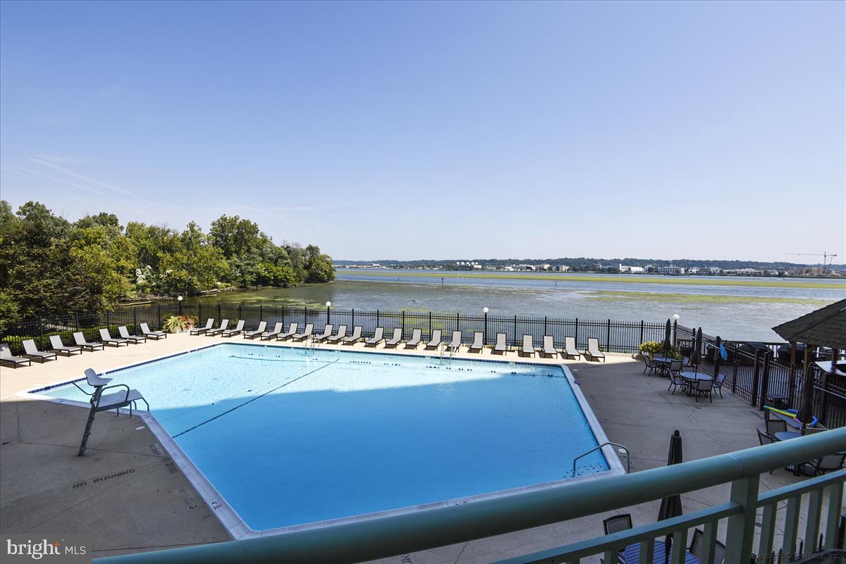 a view of swimming pool with outdoor seating and lake view