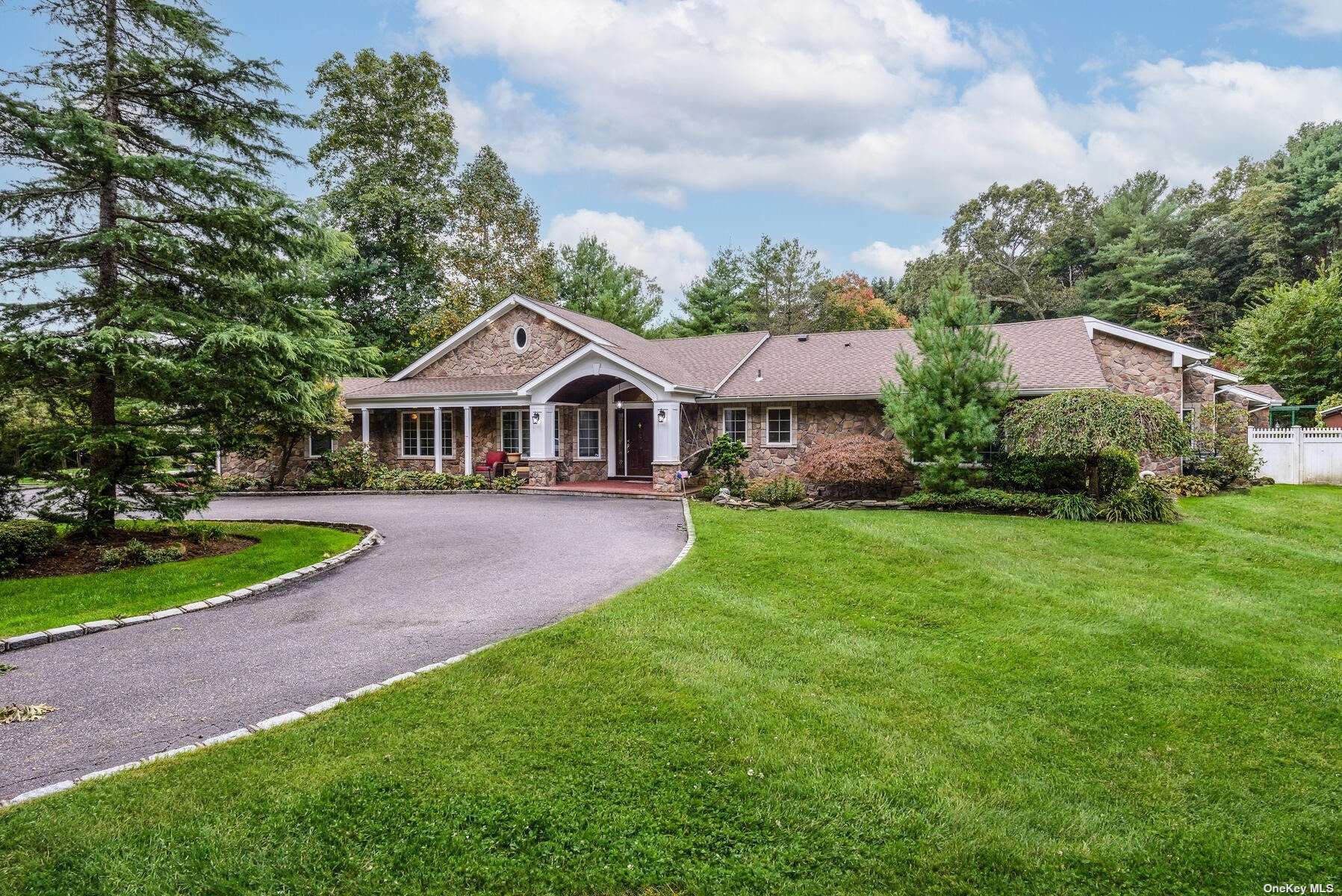 a front view of a house with a yard and green space