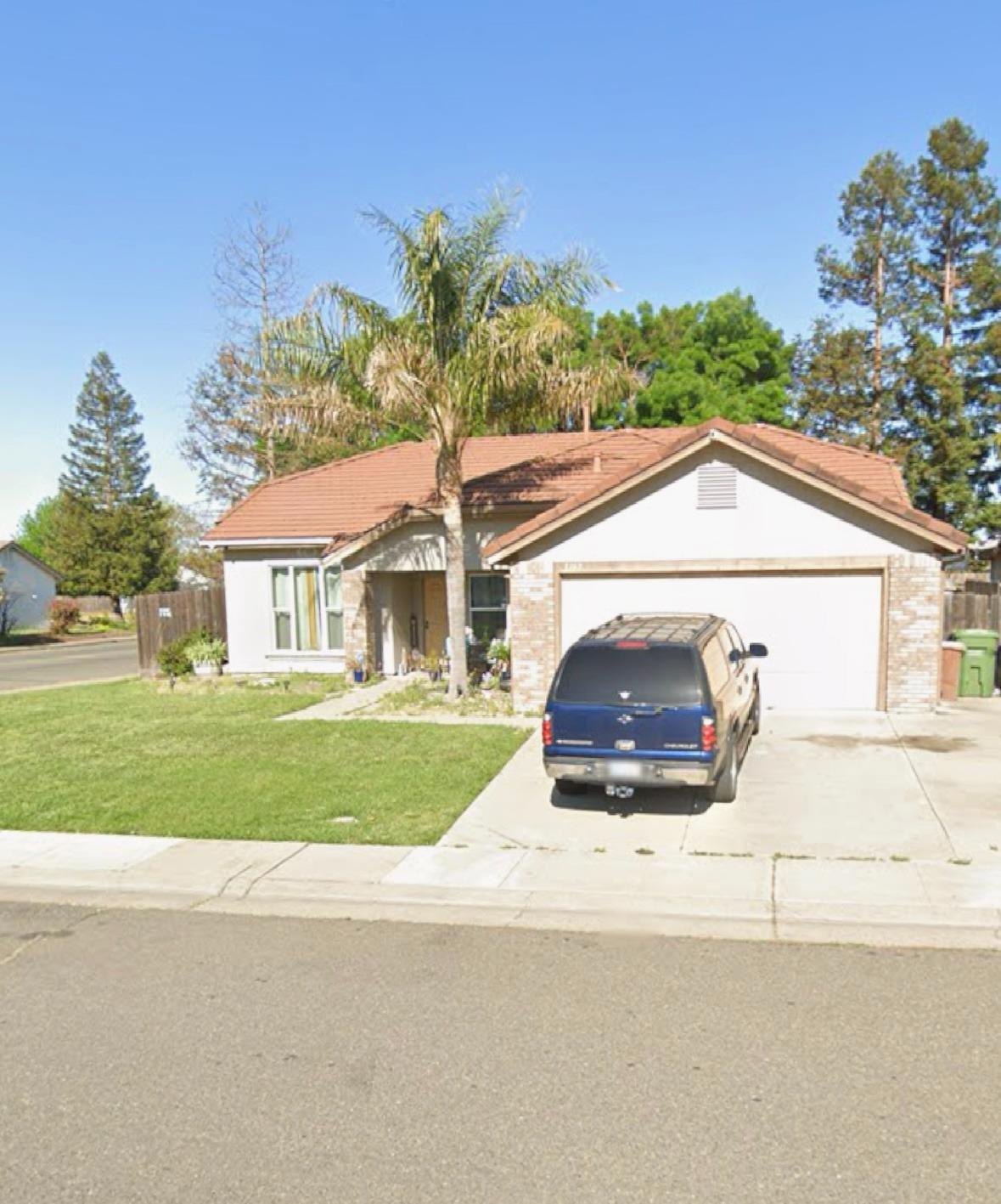 a view of house with a yard and potted plants