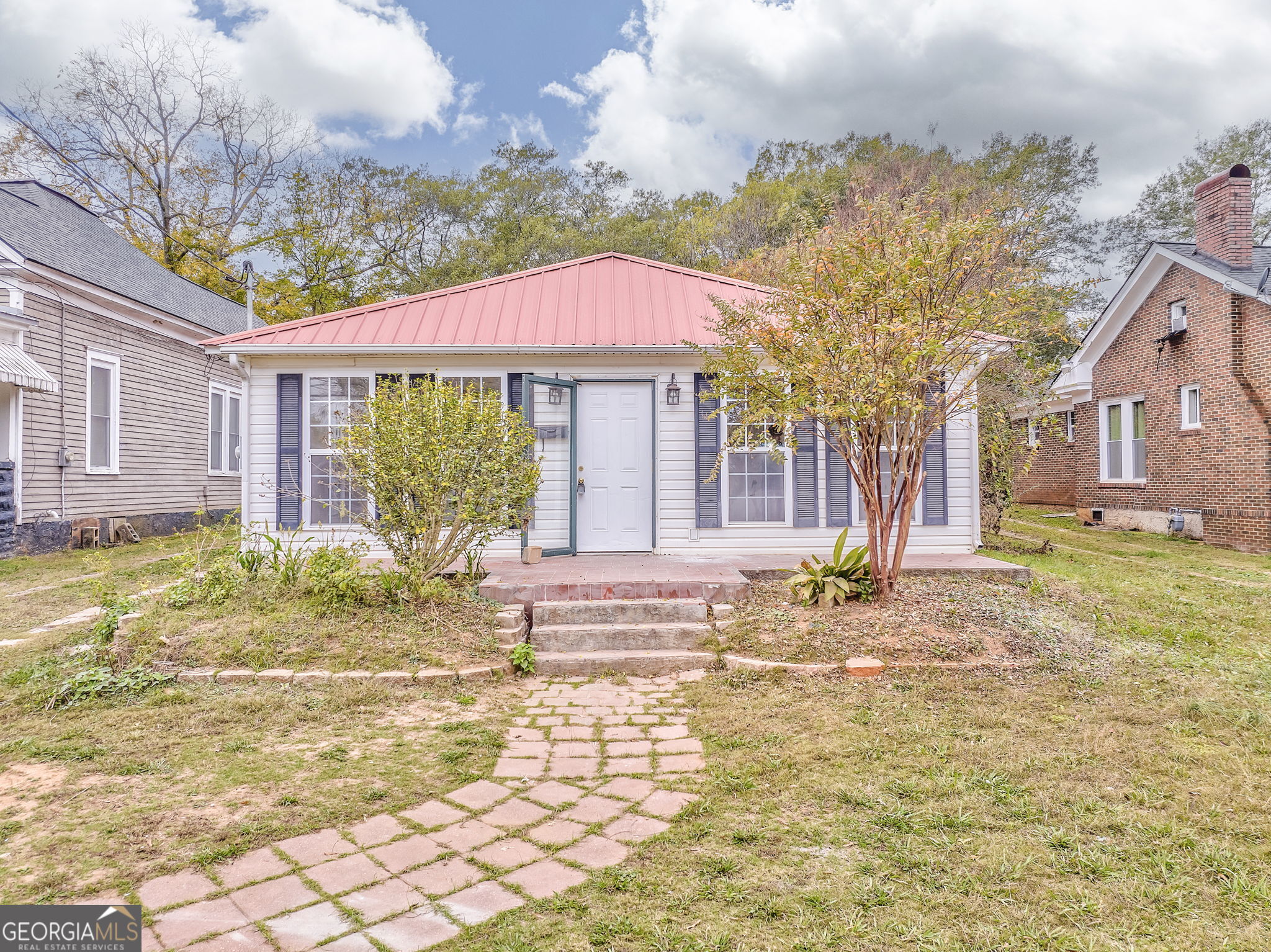 a view of house with yard and sitting area