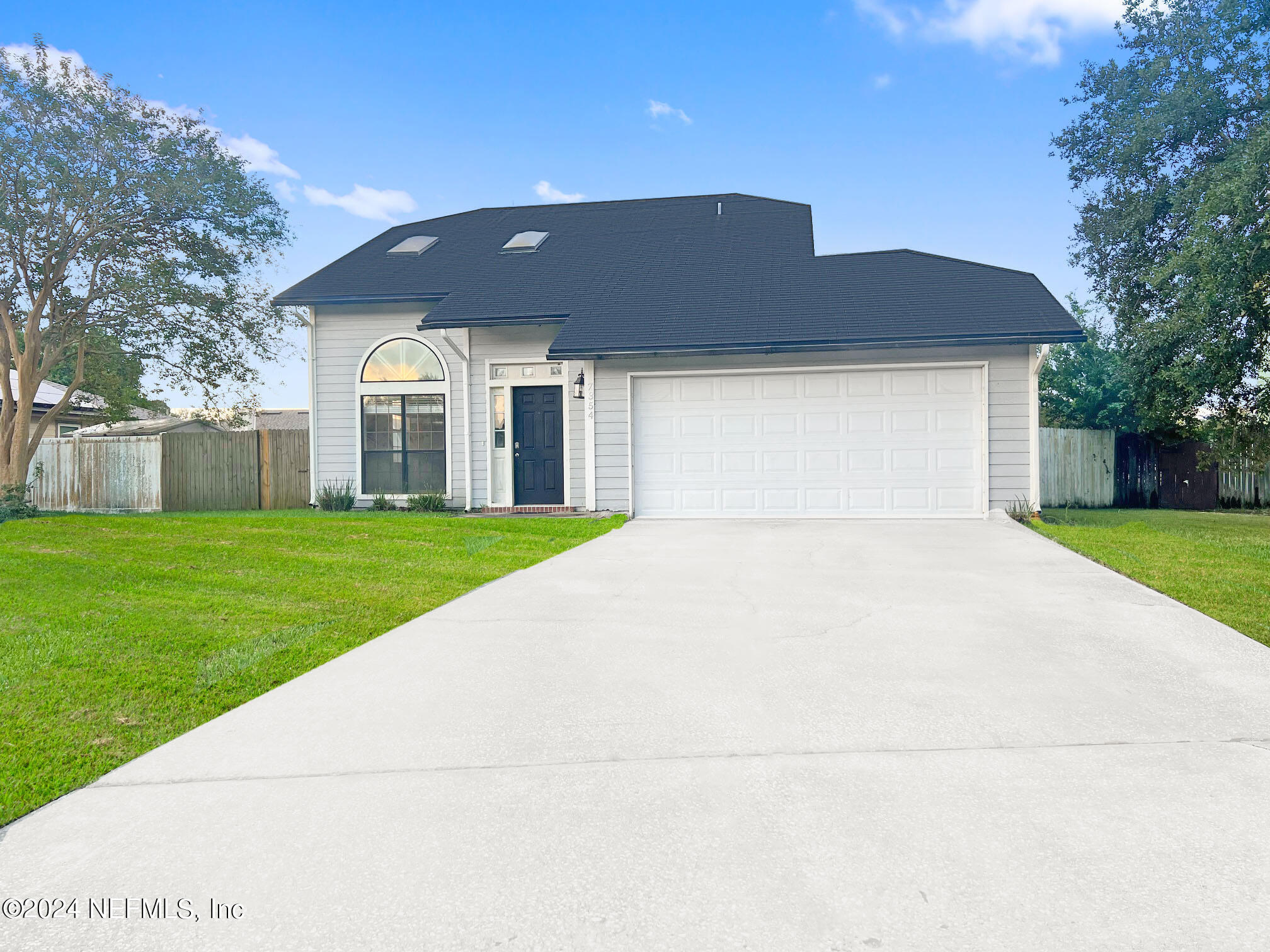 a front view of house with yard and garage