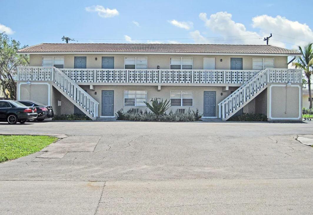 a front view of a house with a yard and car parked