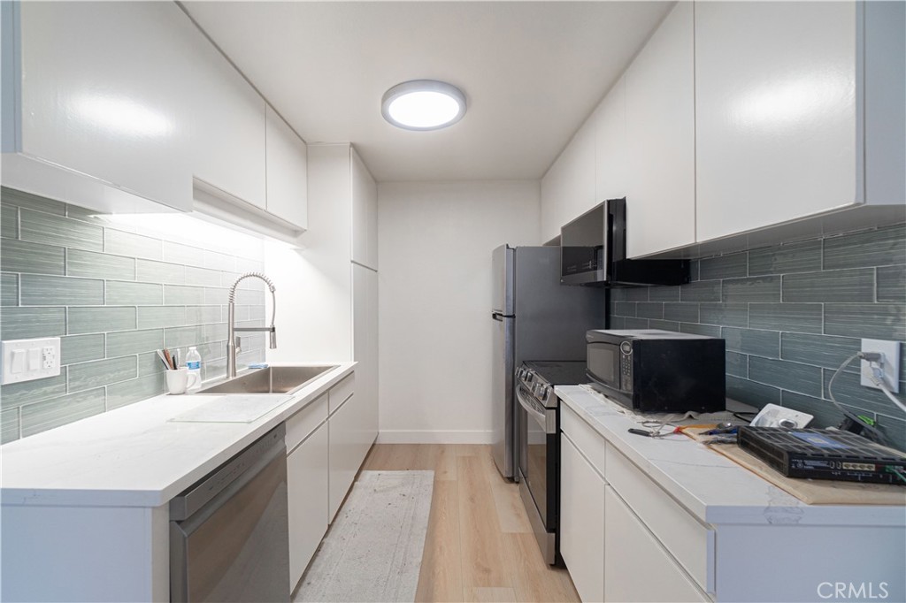 a kitchen that has a sink and a stove in it