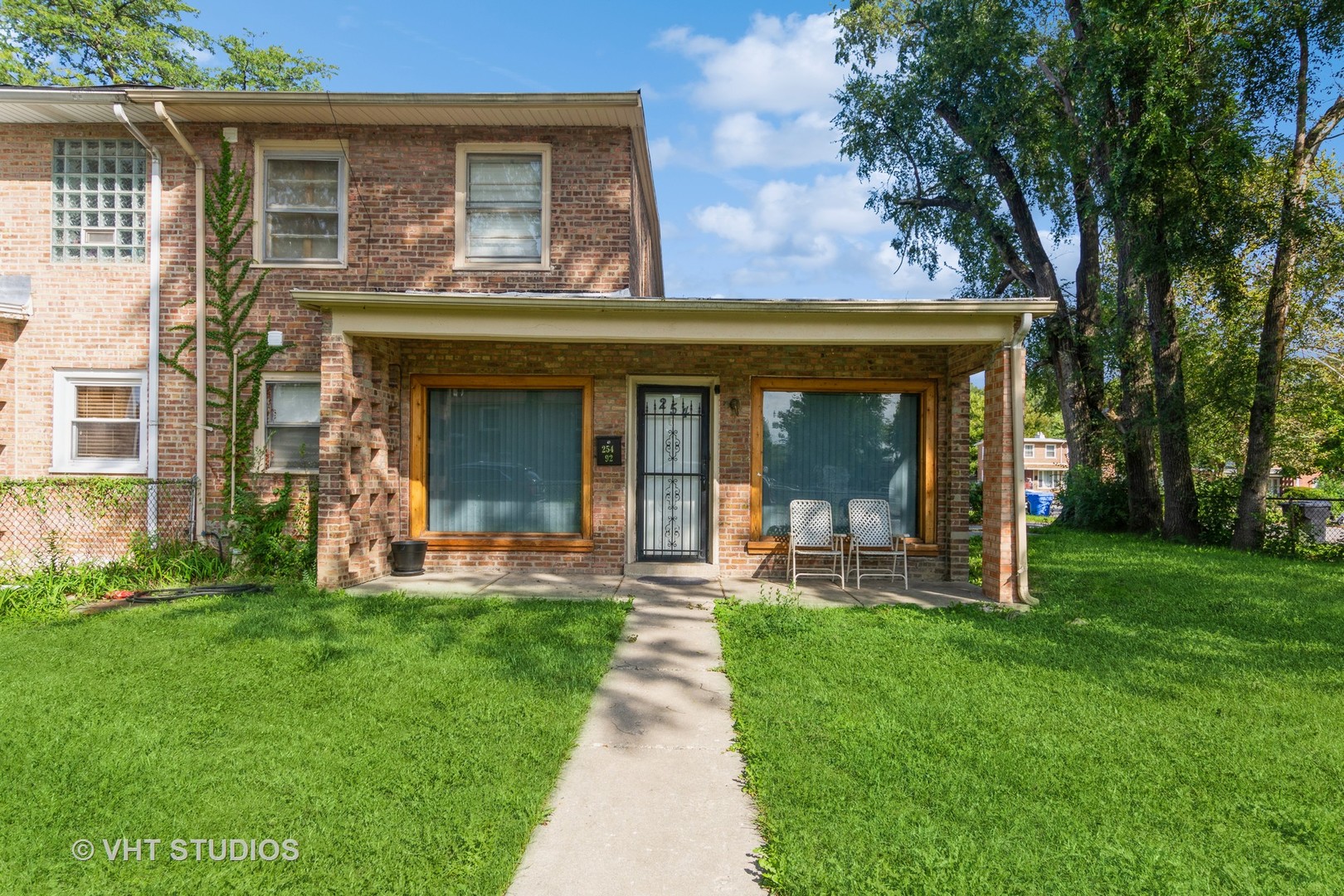 front view of a brick house with a yard