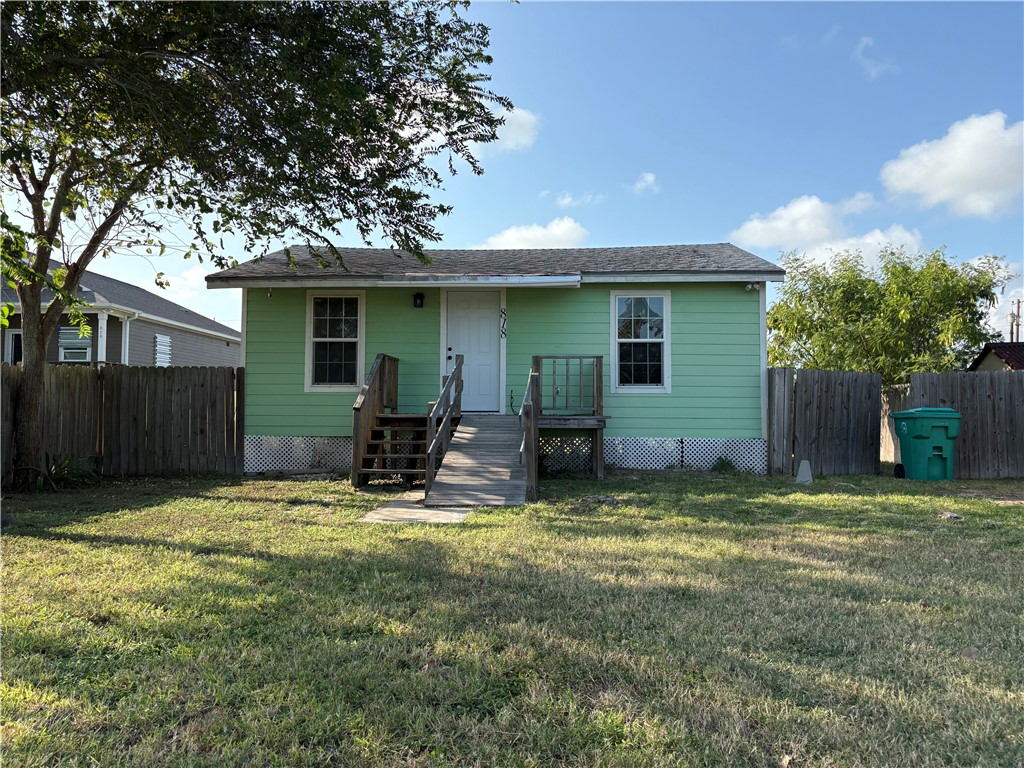 a view of a backyard with table and chairs and wooden fence