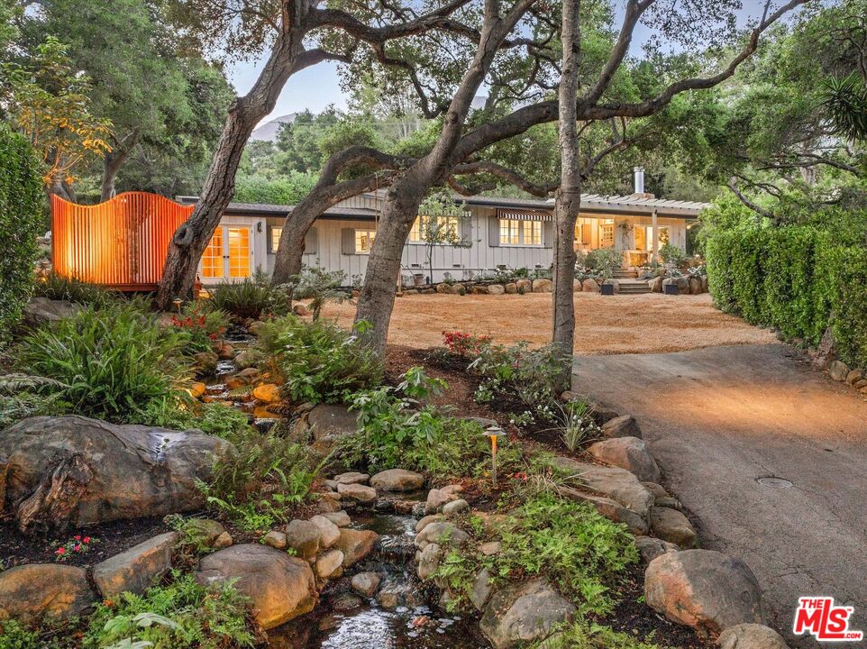 a front view of a house with a yard and tree s