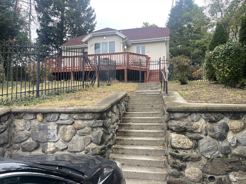 a view of a brick house with a wooden deck