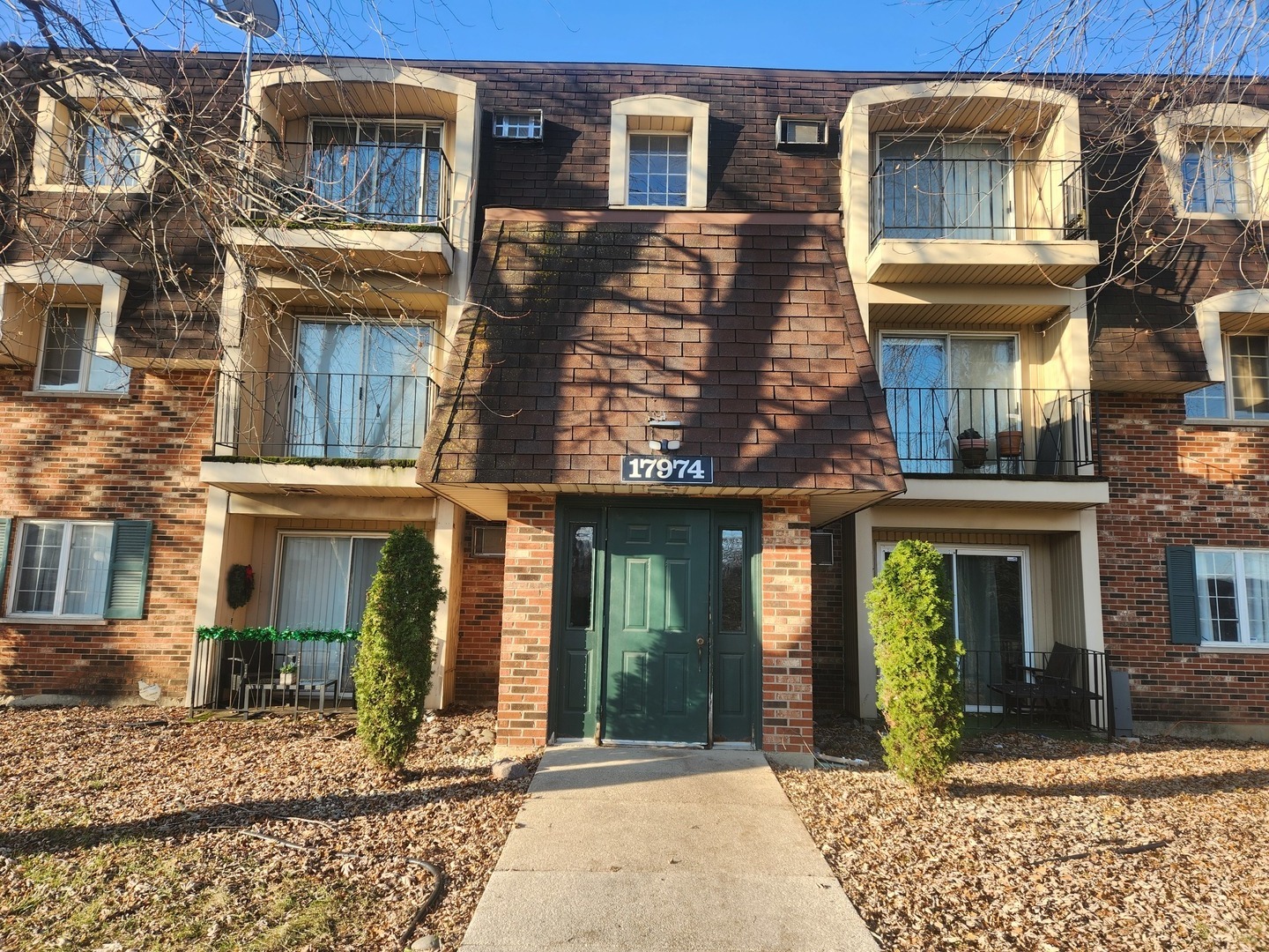 front view of a brick house with a blue windows