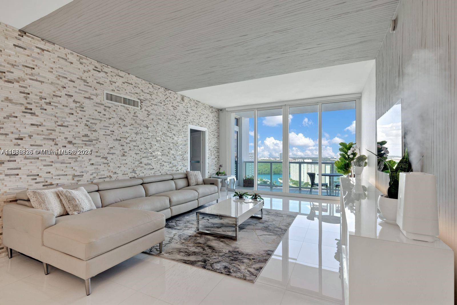 a living room with furniture large windows and wooden floor