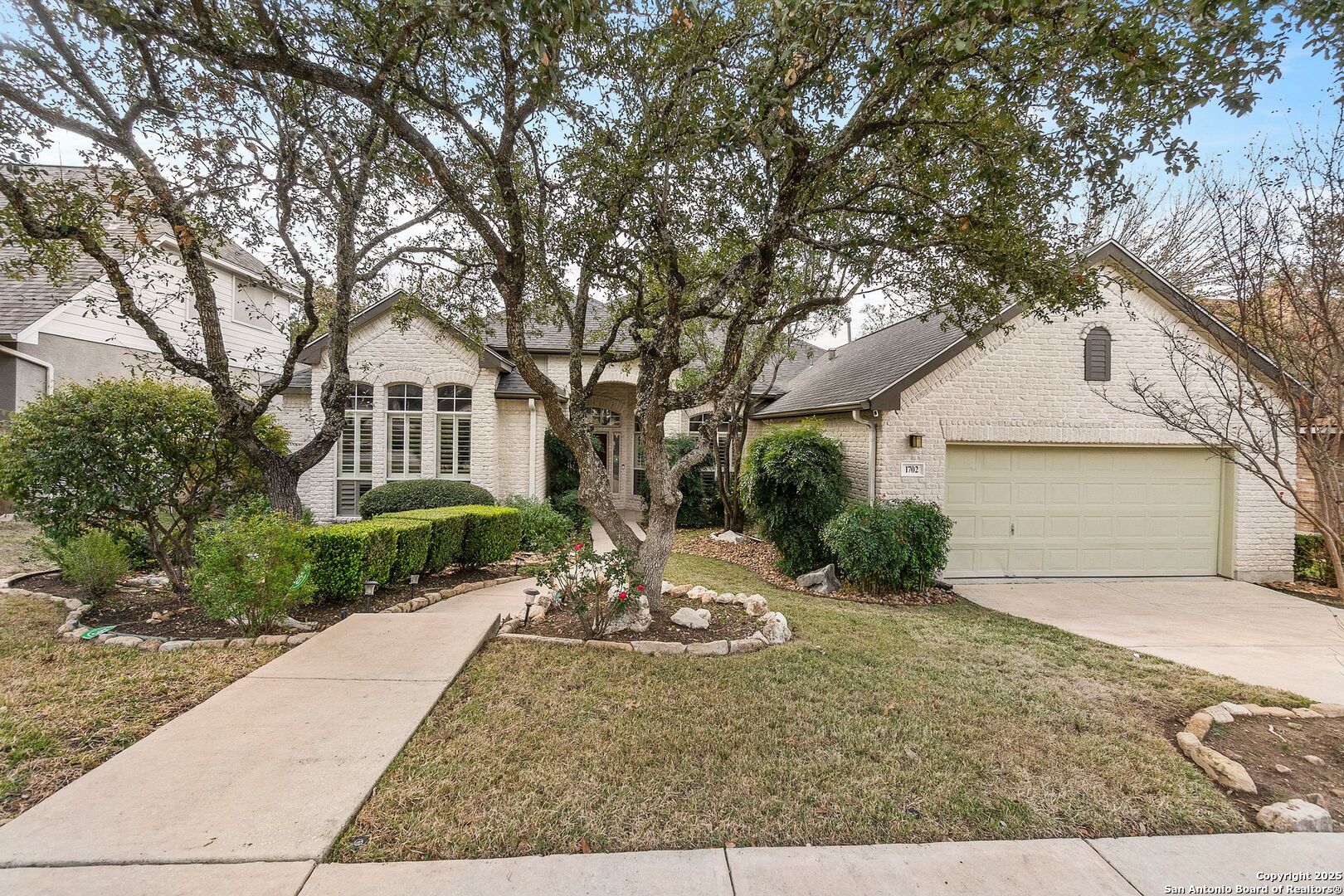 a front view of a house with a yard and tree s