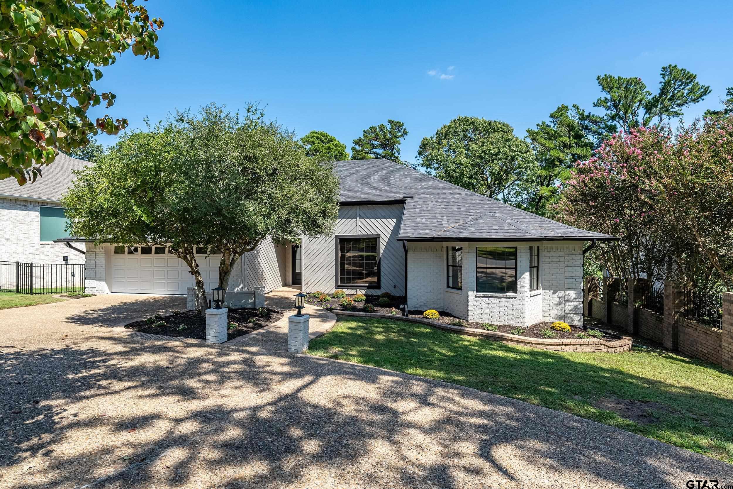 a front view of a house with a yard tree and outdoor seating