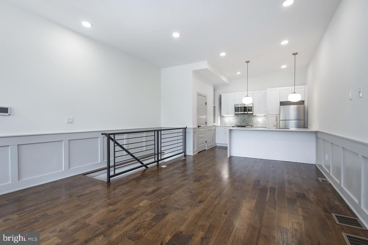 a view of kitchen with wooden floor and electronic appliances