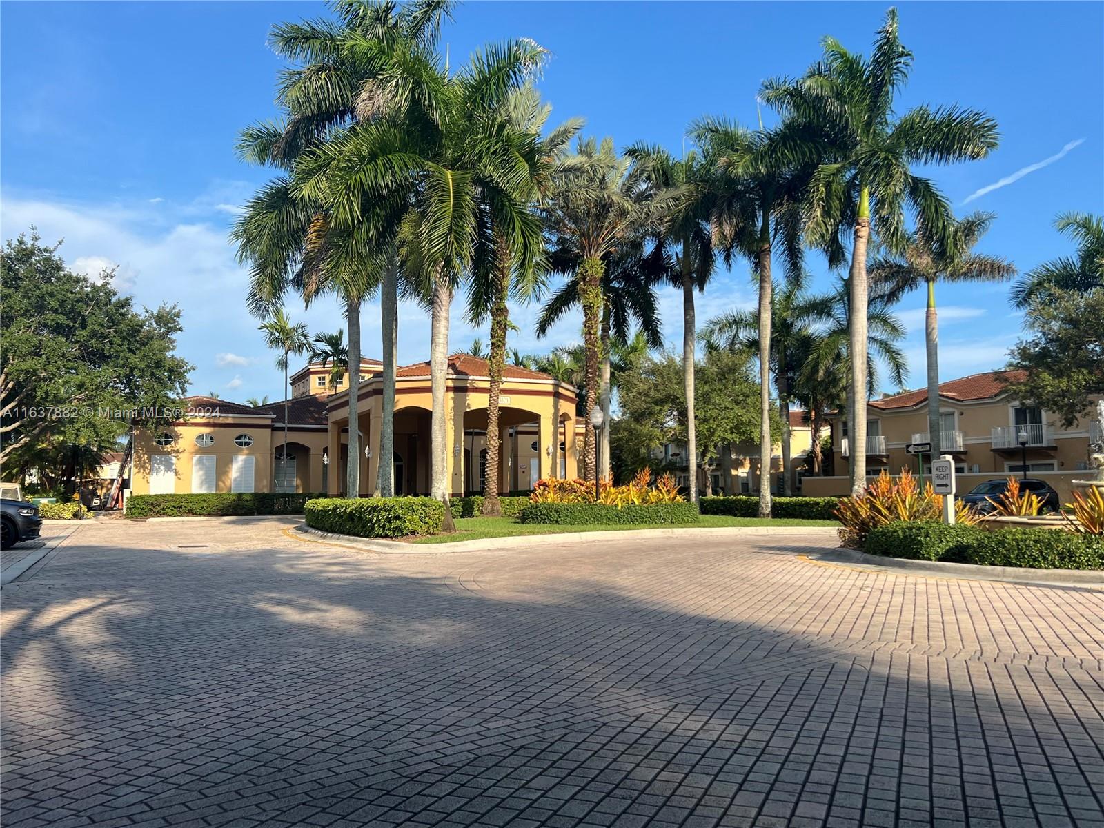 a view of a house with a yard and palm trees