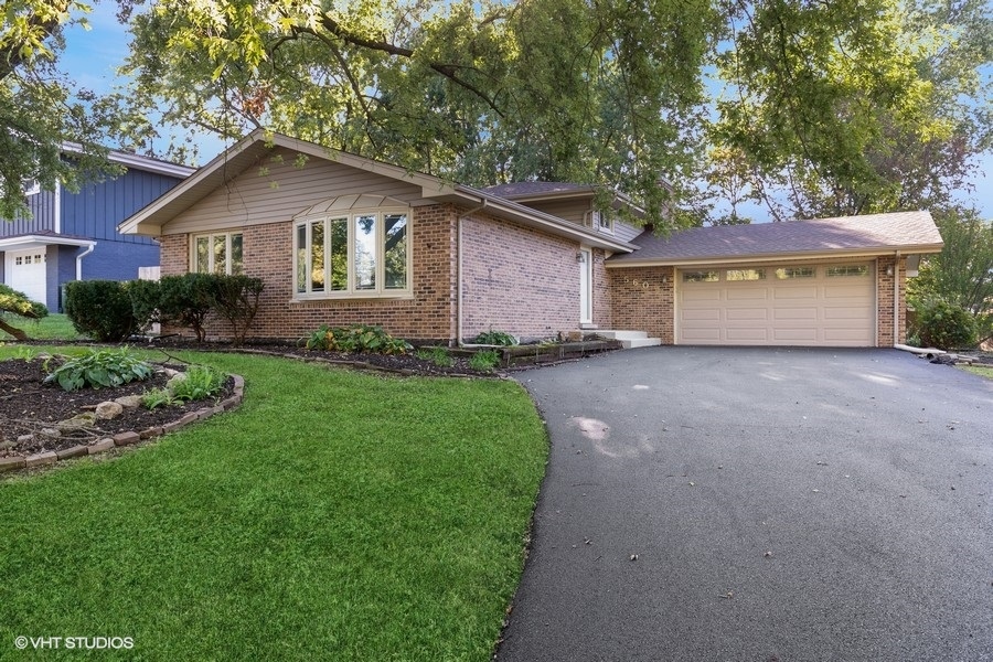 a front view of a house with a garden and yard