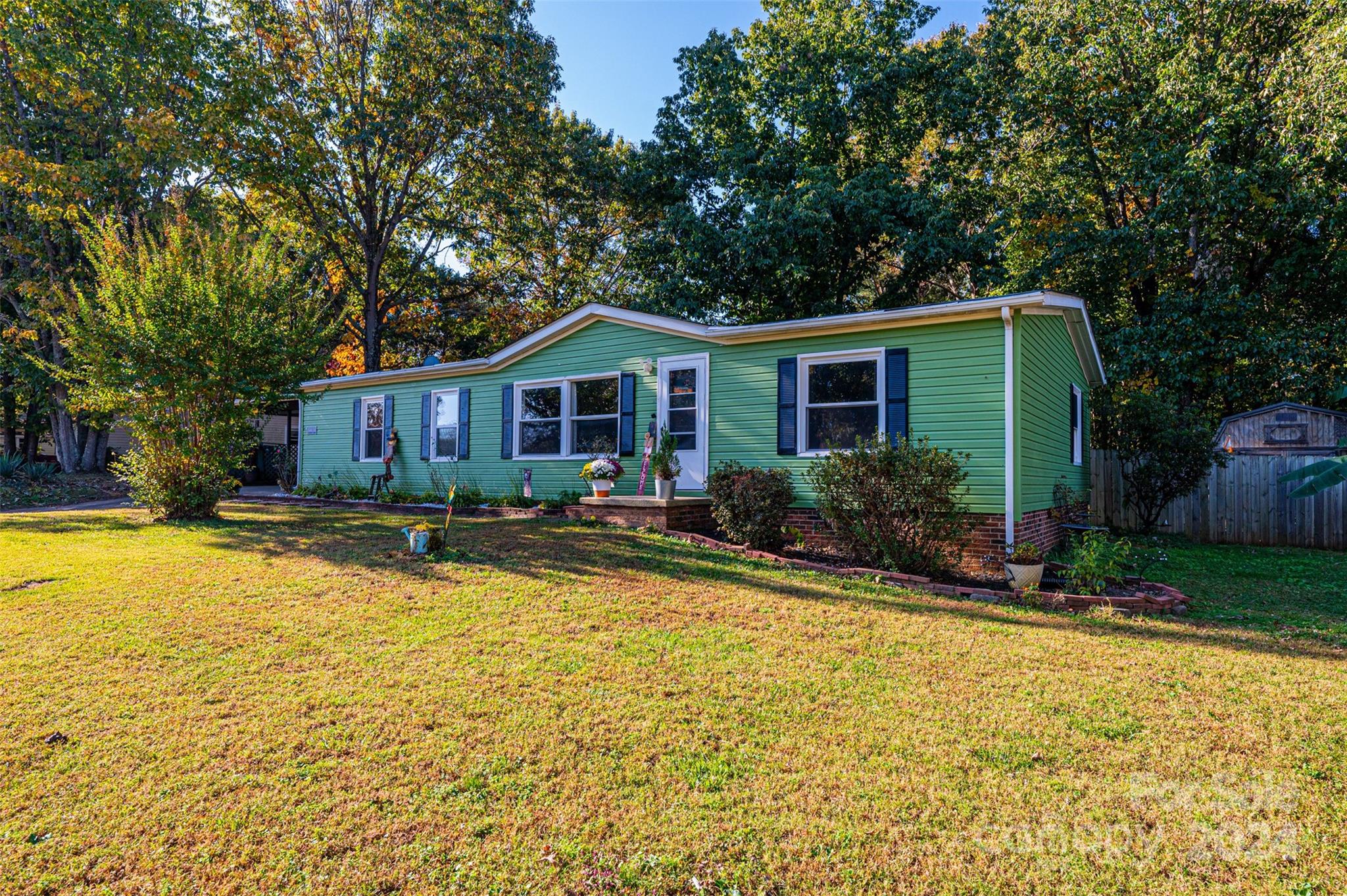 a front view of house with yard and trees around