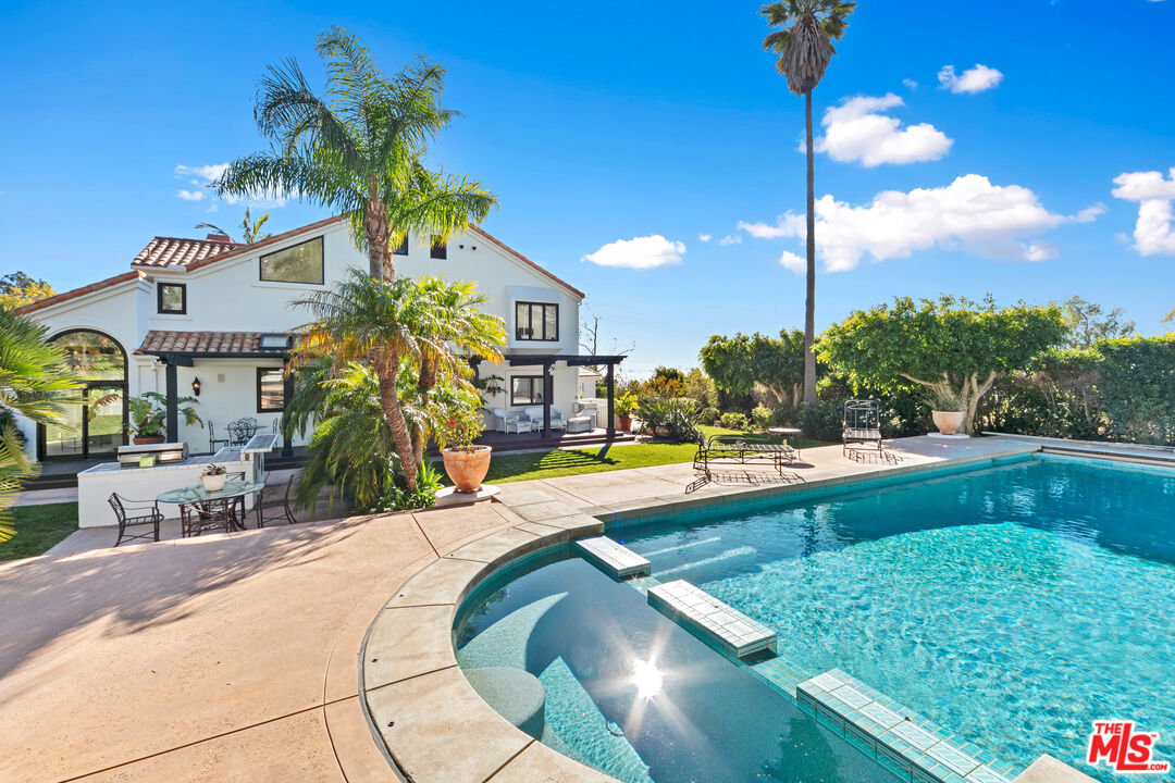 a view of a house with swimming pool and sitting area