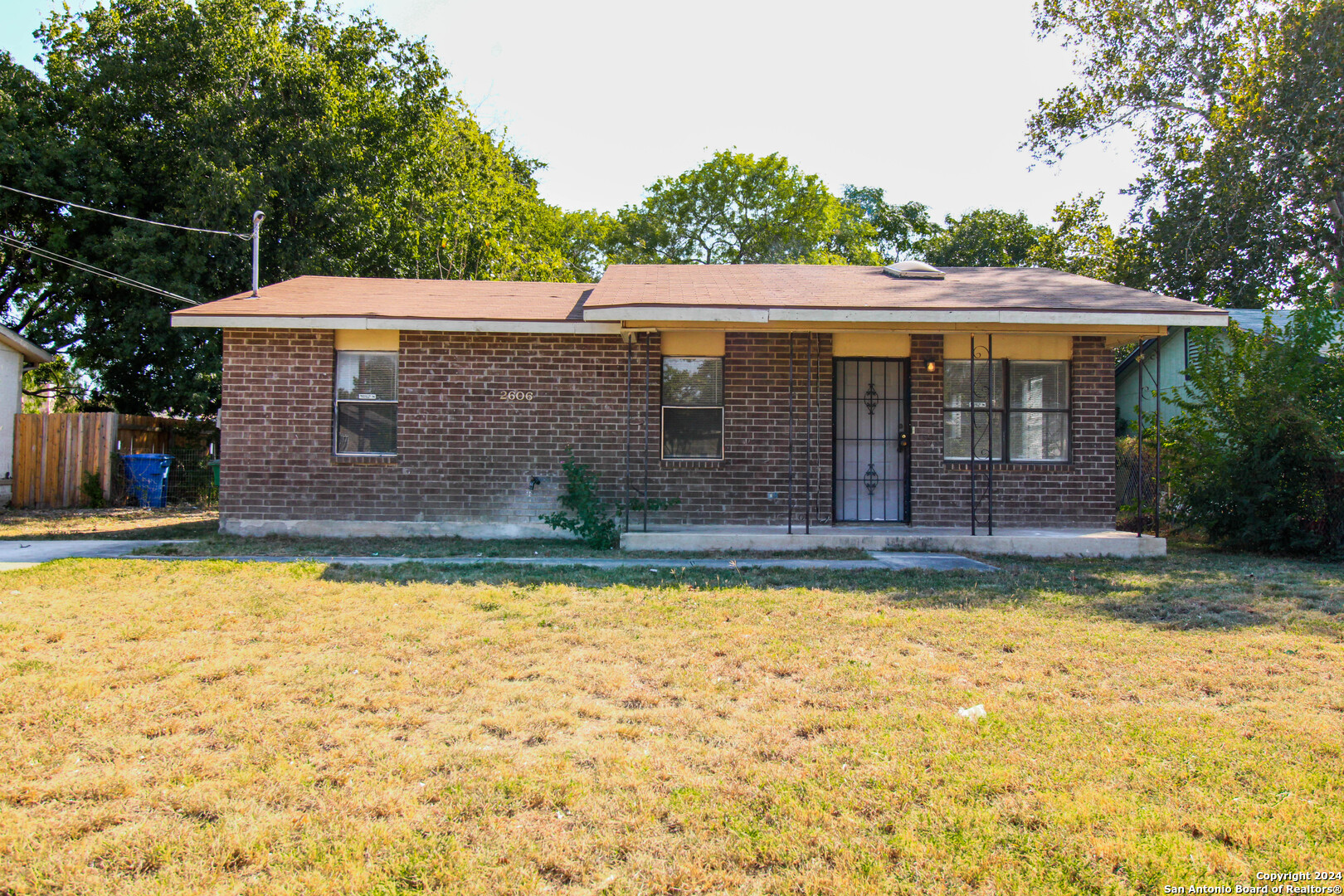 a view of house with yard outdoor seating and covered with trees