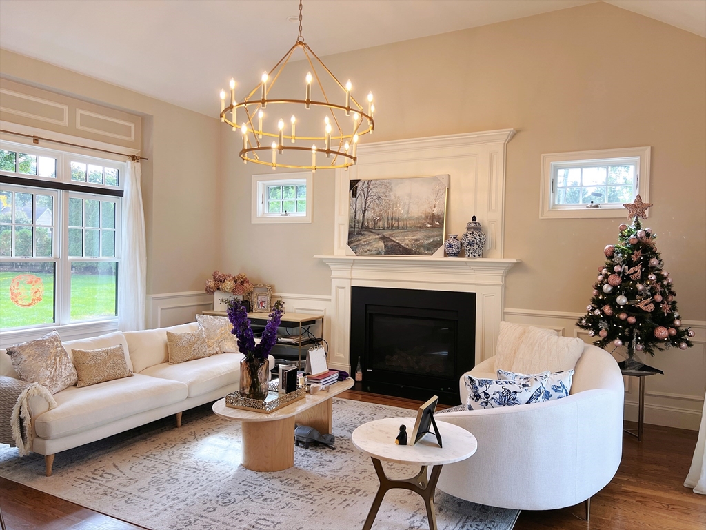 a living room with furniture a chandelier and a fireplace