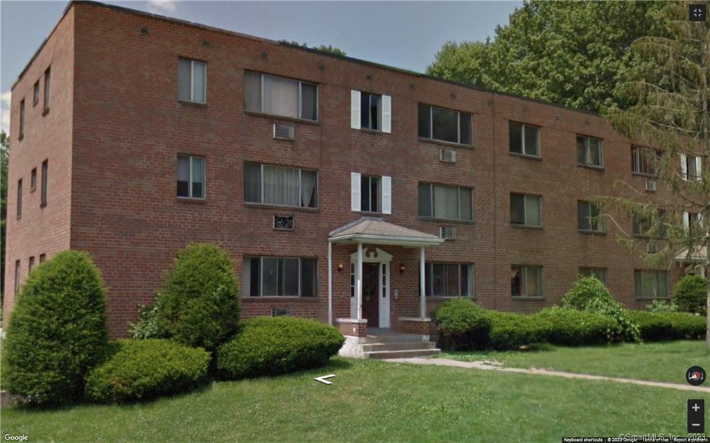 front view of a brick house with a yard