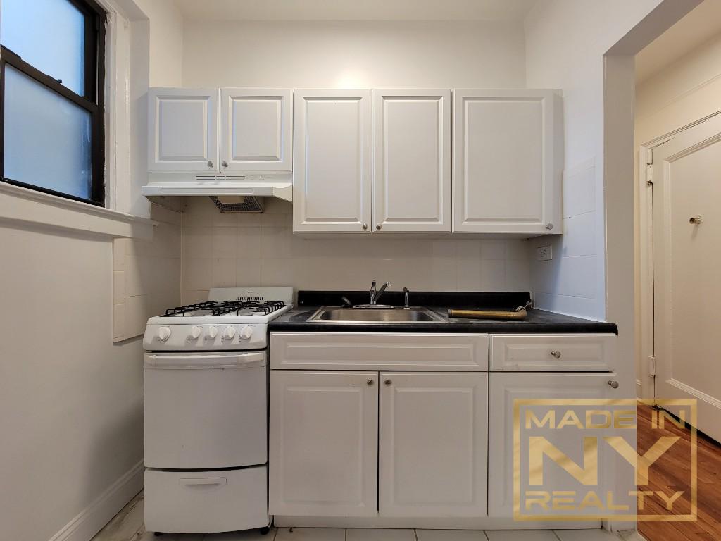 a kitchen with white cabinets and white appliances