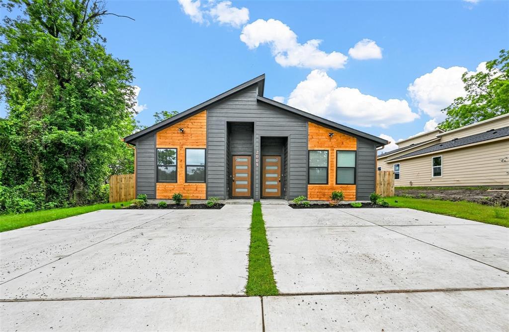 a view of a house with backyard and a parking space