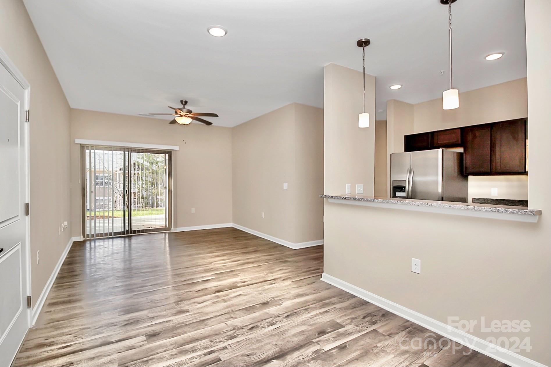 wooden floor in an empty room with a kitchen