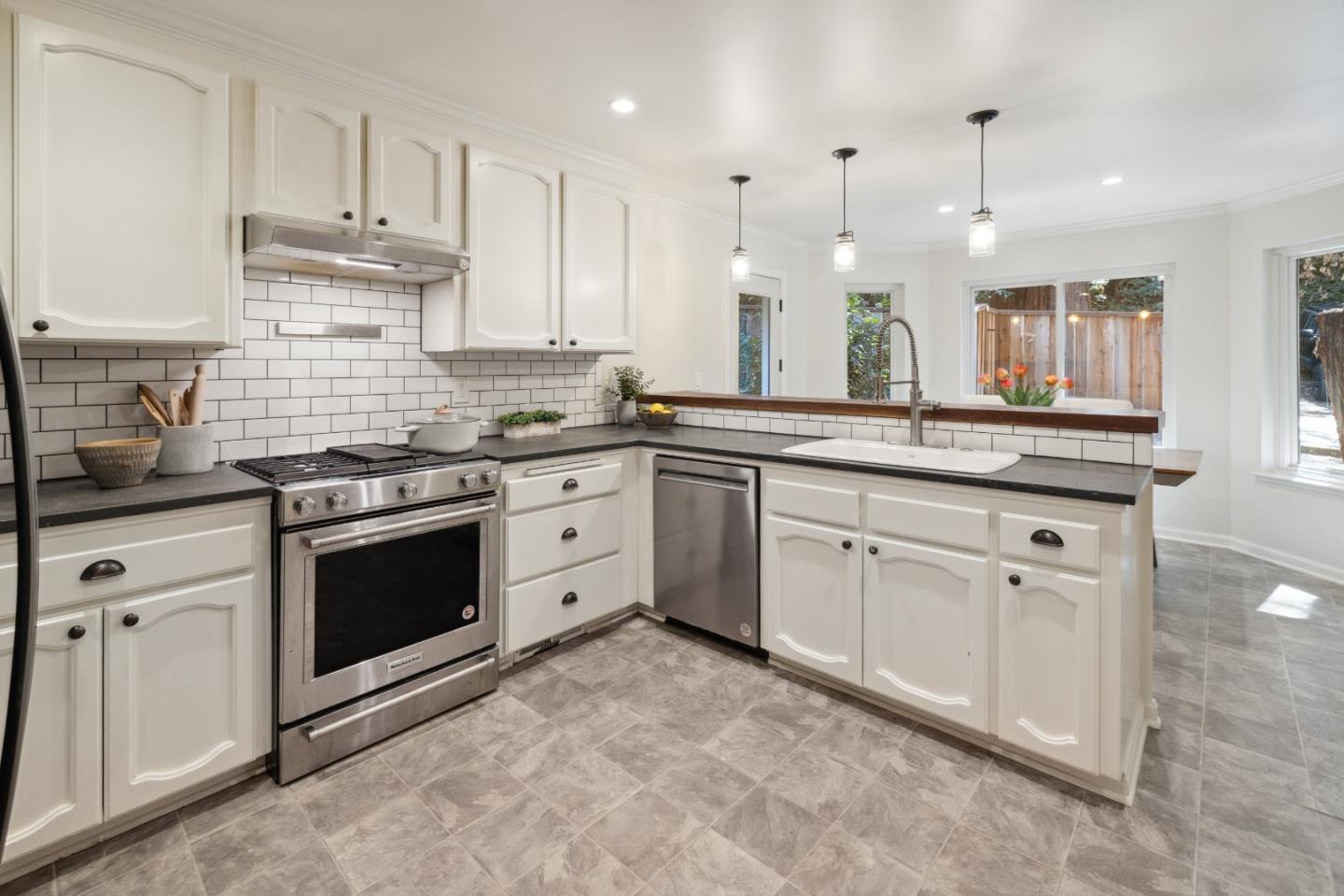 a kitchen with white cabinets stainless steel appliances and sink