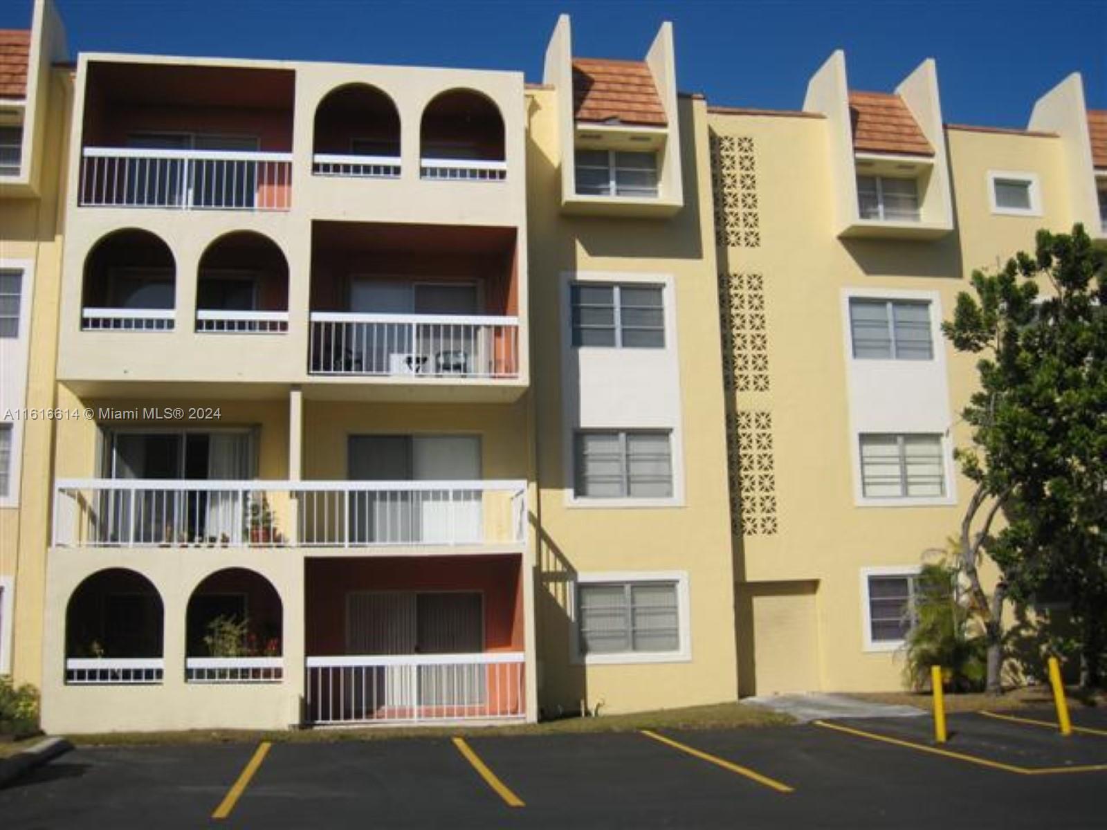 a front view of a residential apartment building with a yard