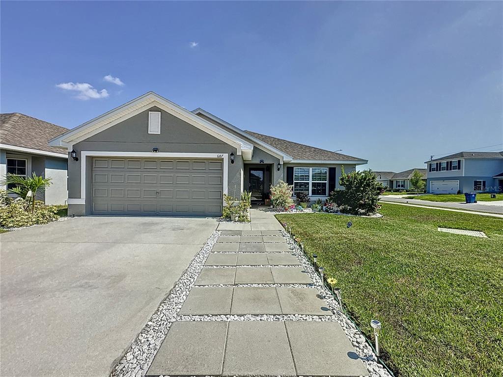 a front view of a house with a yard and garage